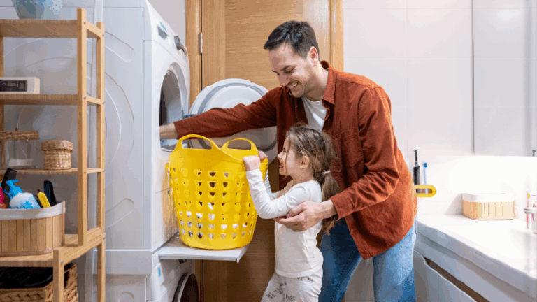 a dad and his daughter putting clothing into the laundry