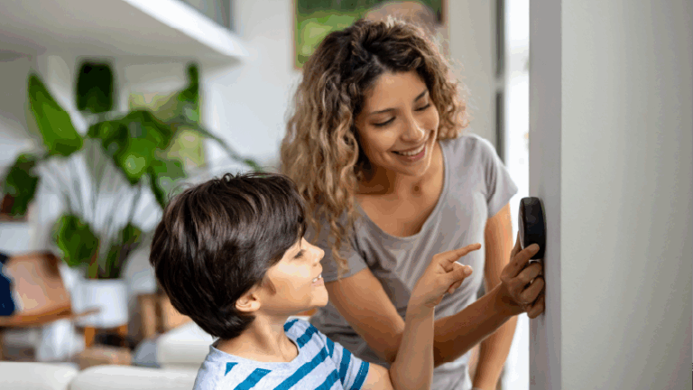 woman adjusting a thermostat with her son watching