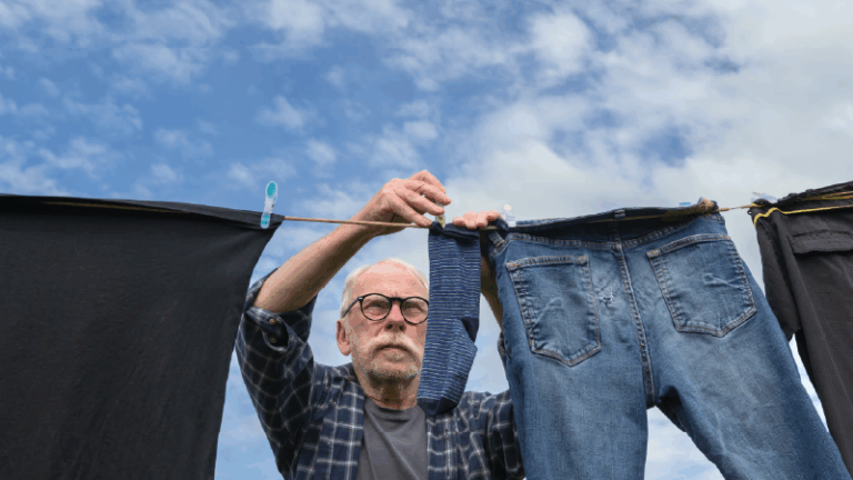 man hanging clothes outside to dry