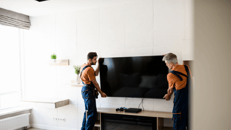 movers setting up a TV set in a room